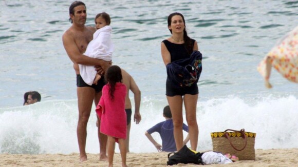 Cláudia Abreu passa sábado em família na praia usando maiô retrô