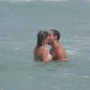 Após o treino, Julio Rocha e Patricia Gutkoski correram para o mar. Apaixonados, eles trocaram beijos quentes nas águas da Barra da Tijuca