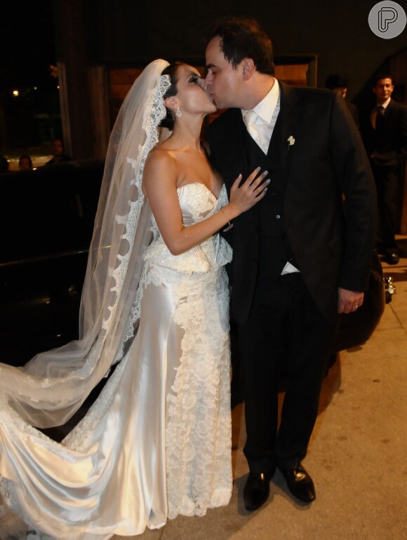 Paola Machado, com um vestido Lethicia Bronstein, beija o marido, Carioca