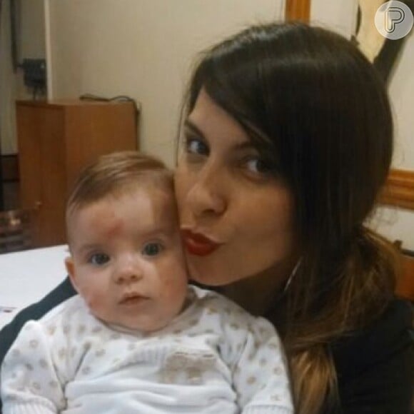 Juliana compartilhou a imagem da filha em seu perfil no Instagram, na qual aparece fofa com faixa na cabeça e macaquinho marinho
