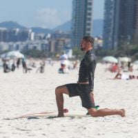 Cauã Reymond faz exercícios na areia antes de surfar em praia do Rio
