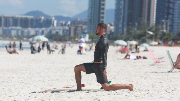 Cauã Reymond faz exercícios na areia antes de surfar em praia do Rio