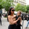 Kim Kardashian caminha com a filha, North West, no colo pelas ruas de Paris, na França, em 20 de maio de 2014