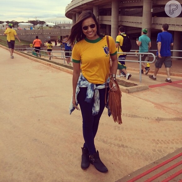 Thaíssa Carvalho, namorada do lateral-direito Daniel Alves, posa para foto na entrada do estádio, minutos antes do jogo começar: 'Cheguei com minha blusa retrô do ano que nasci! Presente da dinda! Salve Garrincha! Rumo ao hexa'