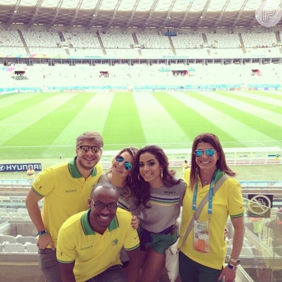 O grupo posa animado diante do campo onde acontece o jogo entre Brasil e Alemanha no Mineirão