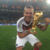 Lukas Podolski posou com a taça após a vitória