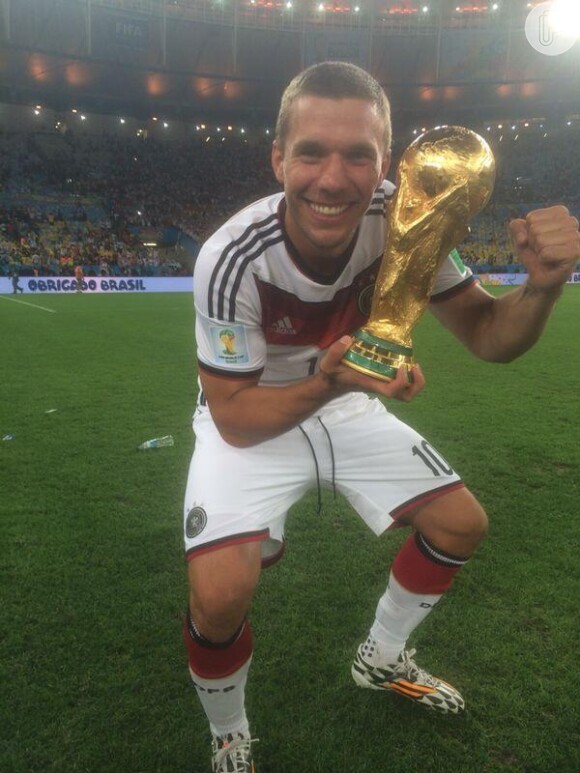 Lukas Podolski posou com a taça após a vitória