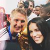 A top brasileira Adriana Lima posa ao lado do atacante da Alemanha Podolski