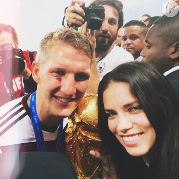 A top brasileira Adriana Lima posa ao lado do atacante da Alemanha Podolski