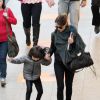 Débora Falabella segura a mão da filha, Nina, no aeroporto