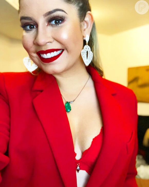 Marília Mendonça apostou em look vermelho com lingerie à mostra e blazer decotado nesta sexta-feira, dia 15 de junho de 2018
