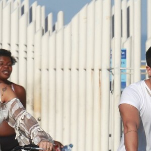 Mayra Cardi, grávida de seis meses, andou de bicicleta na orla da praia da Barra da Tijuca com o marido, Arthur Aguiar