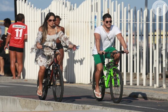 Mayra Cardi, grávida de seis meses, andou de bicicleta na orla da praia da Barra da Tijuca com o marido, Arthur Aguiar