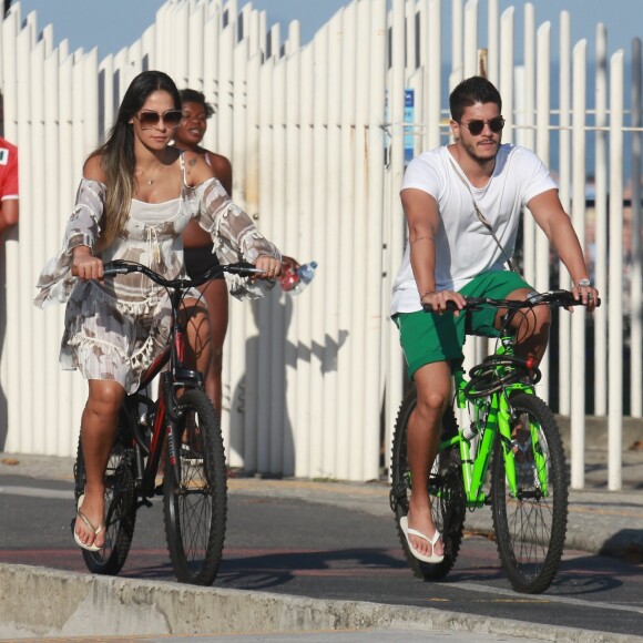 Mayra Cardi, grávida de seis meses, andou de bicicleta na orla da praia da Barra da Tijuca com o marido, Arthur Aguiar