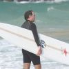 Usando uma roupa de neoprene, própria para a prática do surfe, Humberto Martins entrou no mar com uma prancha de longboard