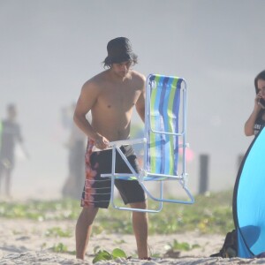 Rafael Vitti abre cadeira na praia enquanto Tatá Werneck atende ligação