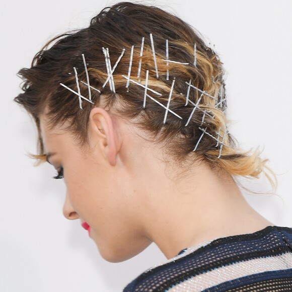 A atriz Kristen Stewart envolveu o cabelo curto com grampos cruzados, compondo um penteado supermoderno