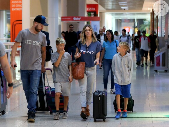 Fernanda Lima e Rodrigo Hilbert conversam com os filhos, Francisco e João, em aeroporto