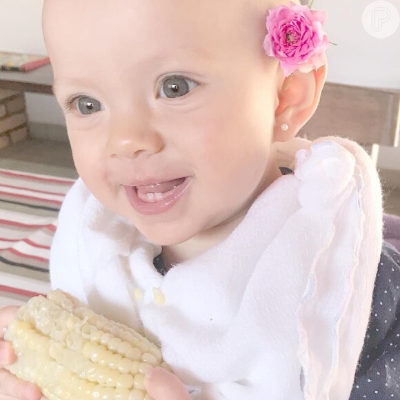 Fofura! Com flor atrás da orelha, Manuela, filha de Eliana, mostrou dentinhos ao comer milho pela primeira vez