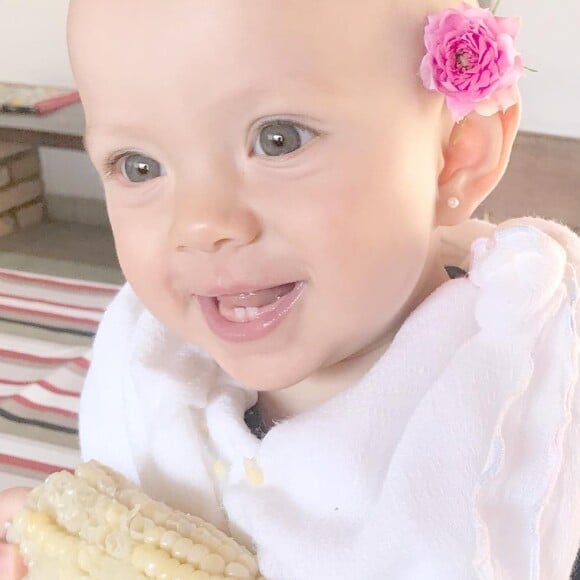 Fofura! Com flor atrás da orelha, Manuela, filha de Eliana, mostrou dentinhos ao comer milho pela primeira vez