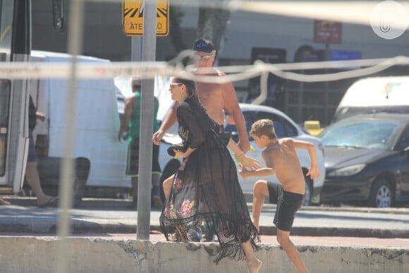 Fernanda Lima ajuda o filho gêmeo Francisco a subir a calçada da orla de Ipanema