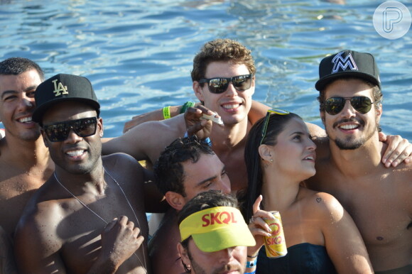 Caio Castro aproveita a festa rodeado de amigos, entre eles, o ator Rafael Zulu, que também usa boné e óculos