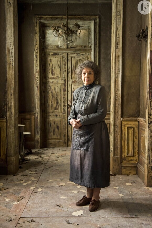 Senhora (Suzana Faini) é a responsável pela guarda da mansão na qual morou Júlia (Vitória Strada) na novela 'Espelho da Vida'