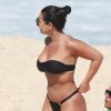 Viviane Araújo arruma biquíni durante dia na praia com amigos