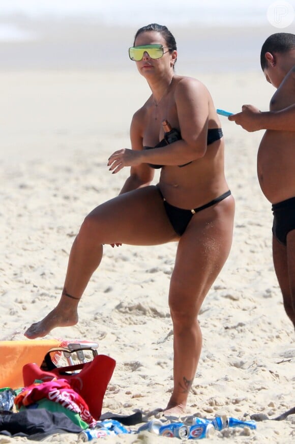 Viviane Araújo passa bronzeador e exibe corpo definido na praia da Barra da Tijuca