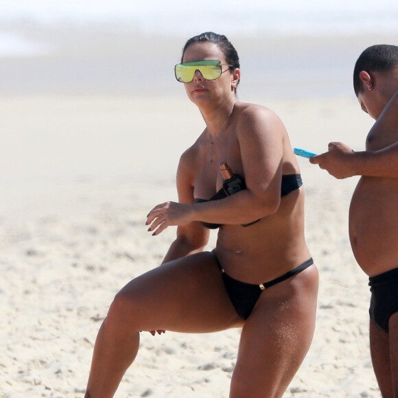 Viviane Araújo passa bronzeador e exibe corpo definido na praia da Barra da Tijuca
