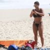 Viviane Araújo passa bronzeador em tarde na praia da Barra da Tijuca