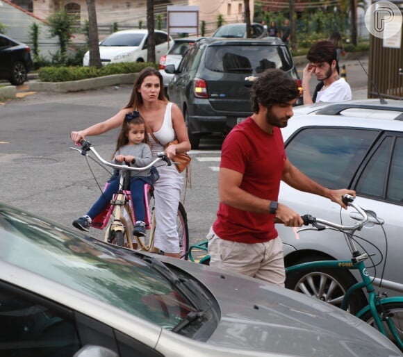 Deborah Secco chega de bicicleta com o marido, Hugo Moura, e a filha, Maria Flor