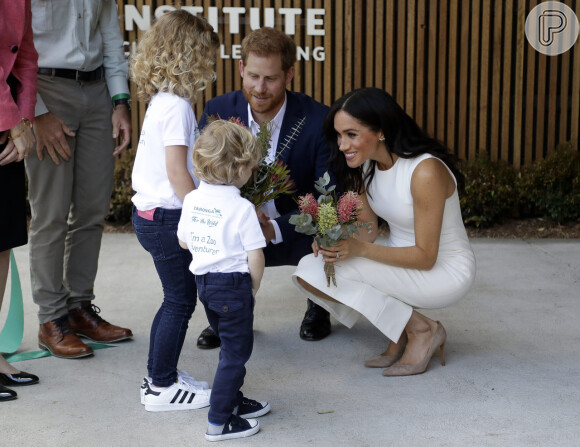 Meghan Markle e príncipe Harry receberam flores de crianças ao desembarcarem na Austrália