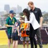 Meghan Markle entrega medalha para menino australiano em evento esportivo