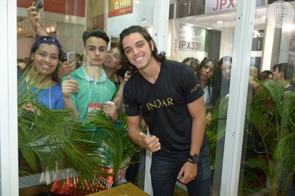 O ator Rodrigo Simas se diverte com fãs em feira de beleza