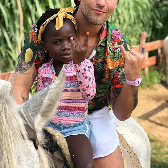 Para passeio de cavalo com o pai, Bruno Gagliasso, Títi usou body de manga, short jeans e tênis vans rosa