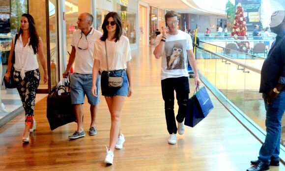Camila Queiroz usou minissaia jeans e camiseta branca. Para completar o visual, bolsa e óculos de sol