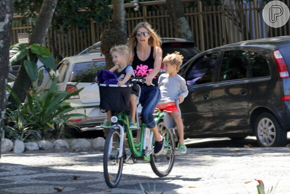 Fernanda Lima se diverte com os gêmeos João e Francisco em passeio de bicicleta