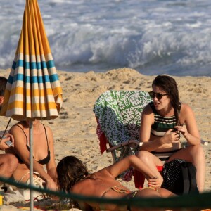 De biquíni listrado, Nathalia Dill curte dia de praia com amigos no Rio de Janeiro