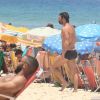 Marcelo Faria caminha na praia lotada