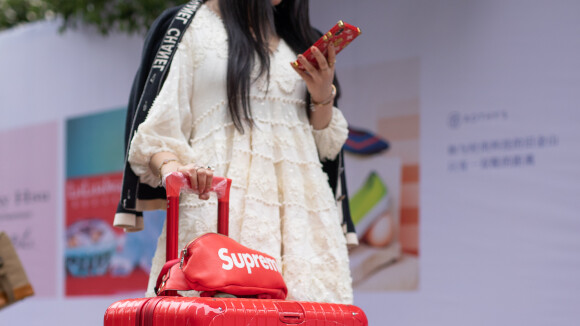 Lisa Hahnbueck wearing red Supreme x Louis Vuitton bag, khaki