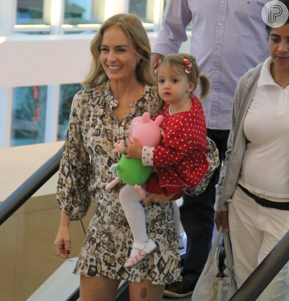 Angélica sorri para o fotógrafo com Eva no colo durante passeio em shopping carioca