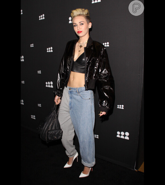 Miley Cyrus investiu no estilo boyish com calça boyfriend, cropped top e finalizou com uma jaqueta de couro