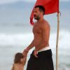 Malvino Salvador caminha com a filha na praia e mostra boa forma