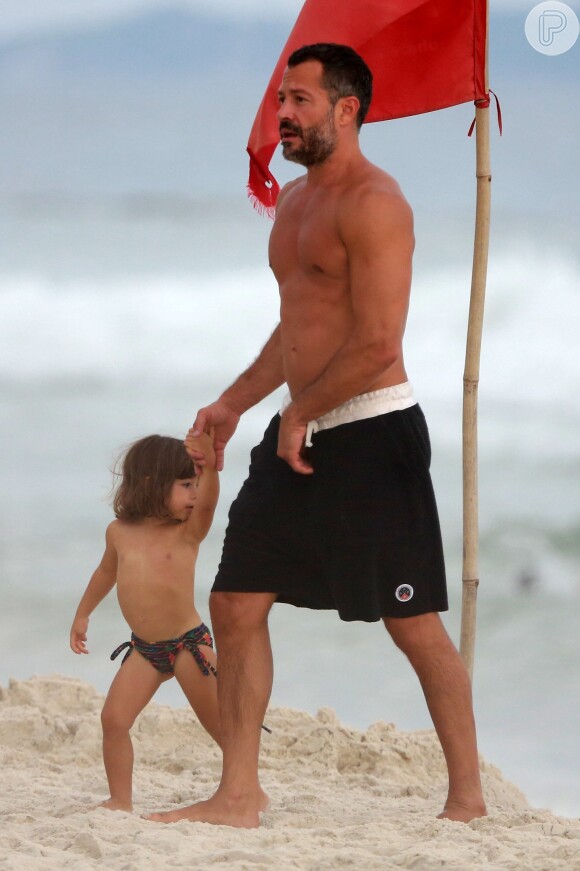 Malvino Salvador caminha com a filha na praia e mostra boa forma