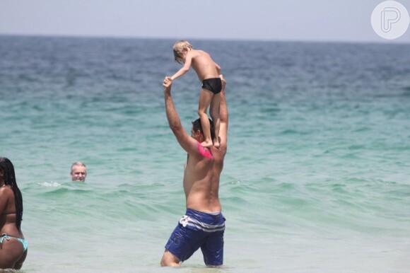 Thiago Lacerda carrega Gael, de 5 anos, no colo e brinca com o filho no mar