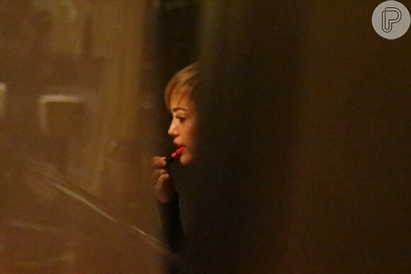 Miley retoca o batom vermelho antes de encontrar o fãs na saída do Sushi Leblon, no Rio