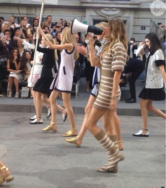 Gisele Bündchen grita palavras de ordem em megafone em desfile-protesto da Chanel