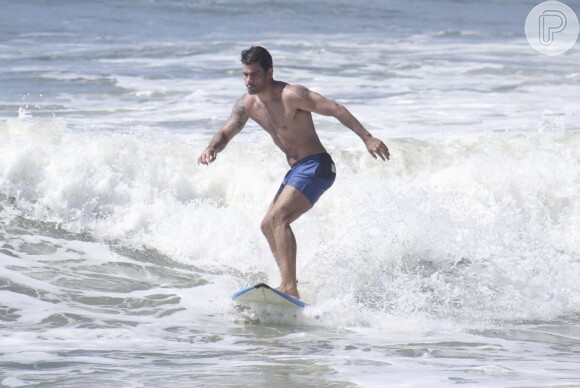 Juliano Cazarré mostra corpão ao surfar em praia do Rio de Janeiro