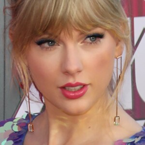 Taylor Swift arrasa no I Heart Radio com macaquinho metalizado e sandália com delalhe de borboleta